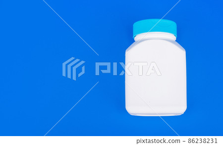 pill jar white color on blue background with copy space, vitamin pill jar white color on blue background with copy space, vitamin 86238231