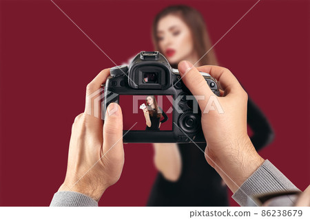 Digital single-lens reflex camera in hands. Man photographer makes photos. Male hands hold the camera close-up Digital single-lens reflex camera in hands. Man photographer makes photos. Male hands hold the camera close-up 86238679