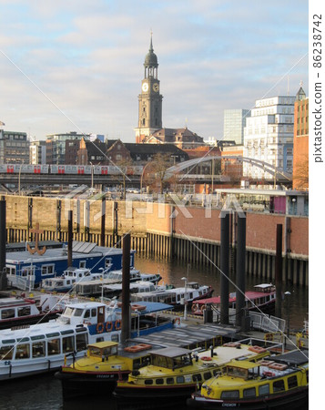 一艘漂浮在港口城市漢堡運河和聖邁克爾教堂鐘樓上的船 86238742