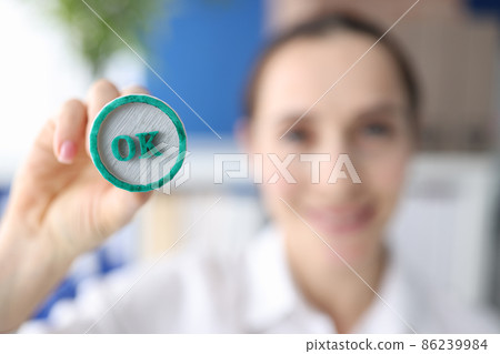 Woman holding green ink stamp OK in her hand closeup Woman holding green ink stamp OK in her hand closeup 86239984