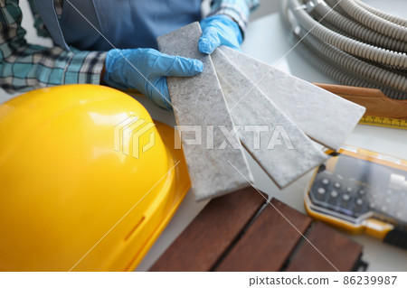 Builder holding gray tiles for bathroom in workshop closeup Builder holding gray tiles for bathroom in workshop closeup 86239987