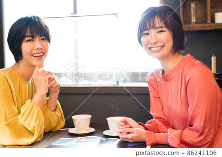 在咖啡廳看小冊子製定旅行計劃的兩個女人拍攝合作“西式糖果店情調” 86241106