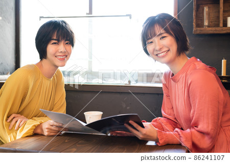在咖啡廳看小冊子製定旅行計劃的兩個女人拍攝合作“西式糖果店情調” 在咖啡廳看小冊子製定旅行計劃的兩個女人拍攝合作“西式糖果店情調” 86241107