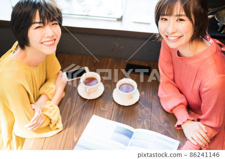 在咖啡廳看小冊子製定旅行計劃的兩個女人拍攝合作“西式糖果店情調” 在咖啡廳看小冊子製定旅行計劃的兩個女人拍攝合作“西式糖果店情調” 86241146