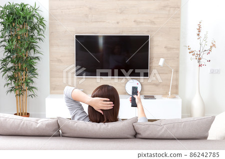 Young woman watching TV in the room Young woman watching TV in the room 86242785