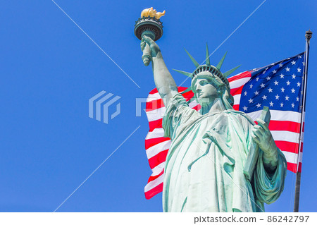 Statue of Liberty with a large american flag and New York skyline in the background Statue of Liberty with a large american flag and New York skyline in the background 86242797