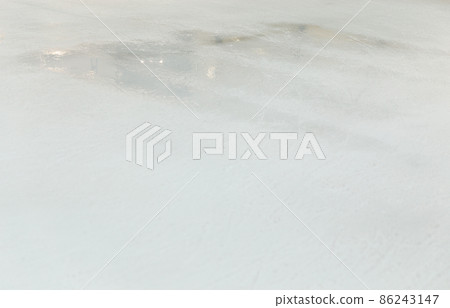 Ice background with marks from skating and hockey, blue texture of rink surface with many scratches Ice background with marks from skating and hockey, blue texture of rink surface with many scratches 86243147