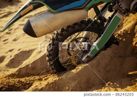 Closeup of motocycle wheel trapped in sand Closeup of motocycle wheel trapped in sand 86243203
