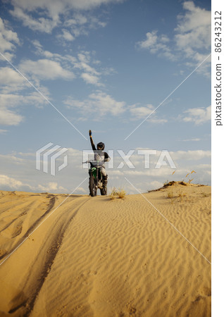 Motorcross rider with raised hand front view 86243212