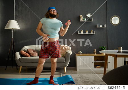 Funny man doing morning workout with dumbbells 86243245