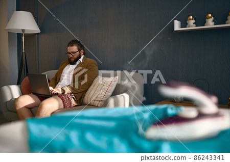 Businessman working on laptop forget about iron 86243341