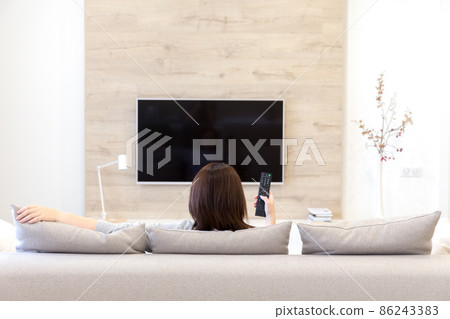 Young woman watching TV in the room 86243383