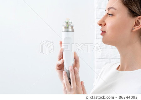Cosmetologist holding medical laser head for rejuvenating face and body treatments Cosmetologist holding medical laser head for rejuvenating face and body treatments 86244092