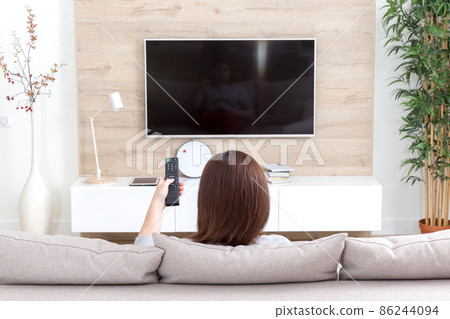 Young woman watching TV in the room 86244094
