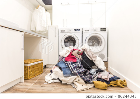 Laudry room with a pile of dirty clothes Laudry room with a pile of dirty clothes 86244343