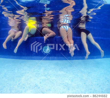 Underwater view of young women having fun in hotel pool. Concept of vacation and bachelorette pool party Underwater view of young women having fun in hotel pool. Concept of vacation and bachelorette pool party 86244882
