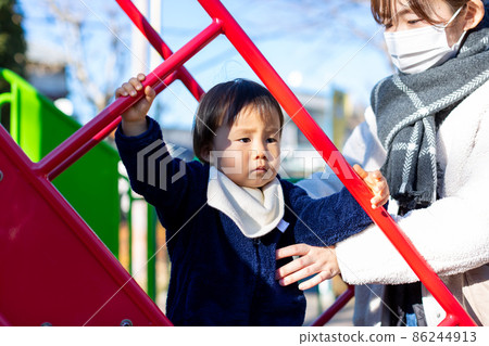 Parent and child playing in the park 86244913
