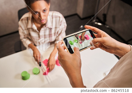 Man shooting at the smartphone how to female blogger cutting kinetic sand Man shooting at the smartphone how to female blogger cutting kinetic sand 86245518