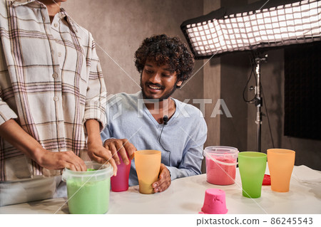 Multiracial man and woman standing at the table and preparing to the live streaming 86245543