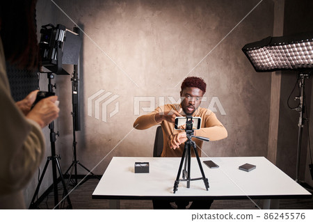 Smart multiracial blogger man filming new blog video with professional camera 86245576