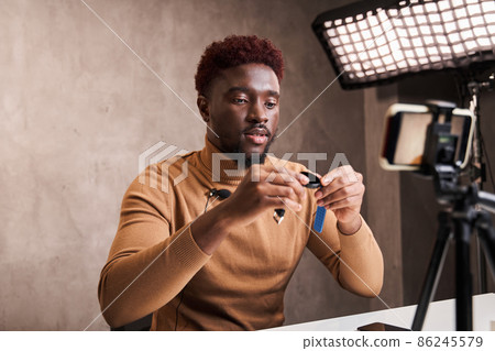 Guy speaking in front of smartphone camera for his blog channel 86245579