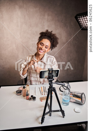 Multiracial woman sitting front of the camera and recording her blog 86245625