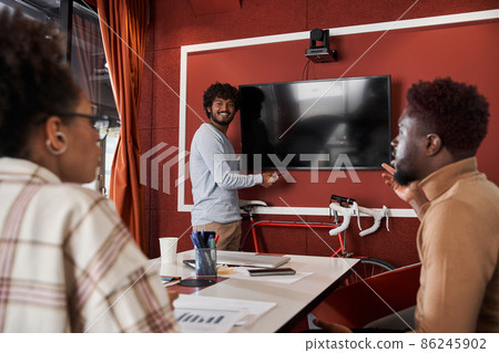 Multiracial colleagues discussing something at the meeting room while sitting at the table 86245902