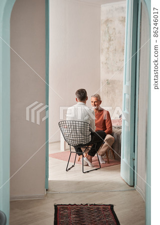 Father and son talking together at the living room during the weekend Father and son talking together at the living room during the weekend 86246017