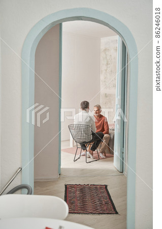 Father and son sitting at the modern flat and talking with each other calmly Father and son sitting at the modern flat and talking with each other calmly 86246018