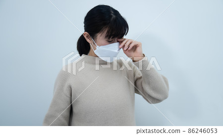 A woman suffering from an allergic reaction to hay fever 86246053