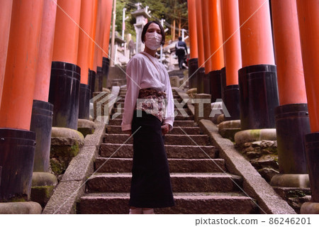 A woman walking through a series of torii gates 1 A woman walking through a series of torii gates 1 86246201