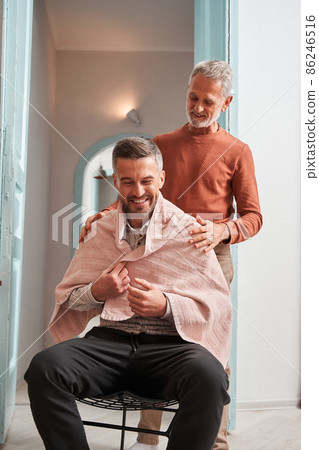 Mature man preparing to making haircut for his adult son at the house Mature man preparing to making haircut for his adult son at the house 86246516