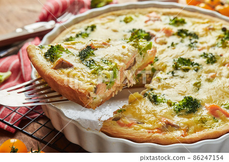 Homemade quiche with red fish, salmon, broccoli and cheese on wooden background Homemade quiche with red fish, salmon, broccoli and cheese on wooden background 86247154