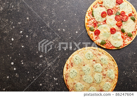 Fast food, Baked frozen pizza Four cheeses and pizza with mozzarella cheese, tomatoes and pesto. Ready to eat Fast food, Baked frozen pizza Four cheeses and pizza with mozzarella cheese, tomatoes and pesto. Ready to eat 86247604