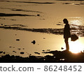 日落時分在沙灘上的男人微明 86248452
