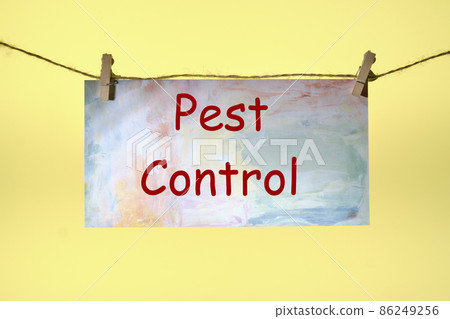 PEST CONTROL text written on paper suspended from a rope on a yellow background ,business idea 86249256