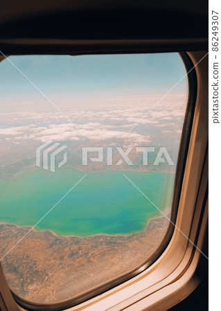 Airplane flight. View from the window of the plane. Airplane, Aircraft. Traveling by air. Airplane Window View Above the Clouds Amazing golden fluffy clouds moving softly Airplane flight. View from the window of the plane. Airplane, Aircraft. Traveling by air. Airplane Window View Above the Clouds Amazing golden fluffy clouds moving softly 86249307