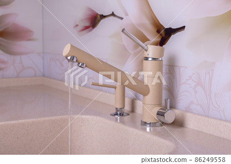 Sand-colored kitchen faucet from which cold water flows Sand-colored kitchen faucet from which cold water flows 86249558