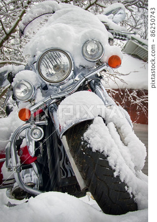 Motorcycle under the snow on winter parking 86250743