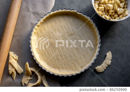 Homemade pie crust in pie plate. Cooking apple pie, dark background. Homemade pie crust in pie plate. Cooking apple pie, dark background. 86250990