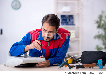Young male repairman repairing heater 86252364