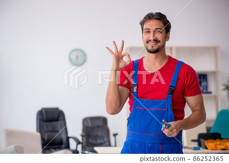Young male repairman working at workshop Young male repairman working at workshop 86252365