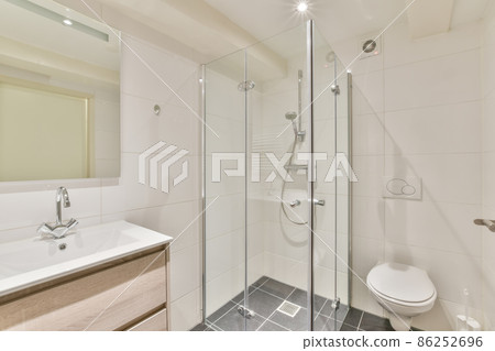 Interior of a modern white bathroom with shower cabinet,toilet,sink,mirror 86252696