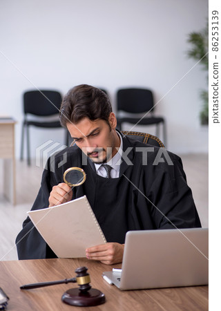 Young male judge working in the courthouse 86253139