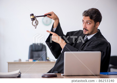 Young male judge working in the courthouse 86253140