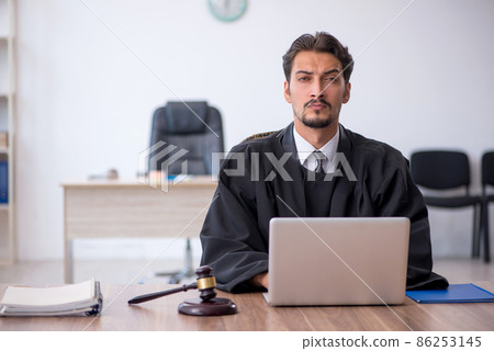 Young male judge working in the courthouse 86253145