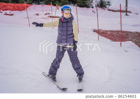 Woman learning to ski. Young woman skiing on a snowy road in the mountains 86254601