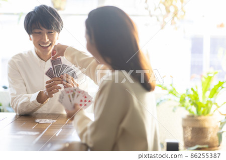 Young men and women enjoying playing cards Young men and women enjoying playing cards 86255387