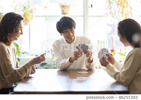 Young men and women enjoying playing cards 86255393