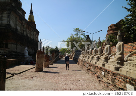 Ayutthaya, a famous tourist attraction in Thailand. A traveler is standing in front of a pile of deity statues Ayutthaya, a famous tourist attraction in Thailand. A traveler is standing in front of a pile of deity statues 86258708